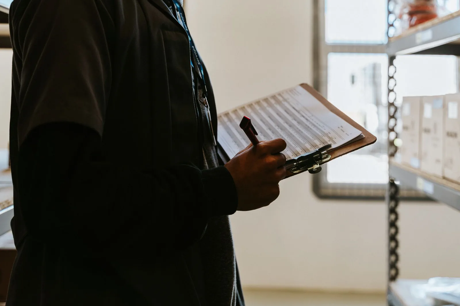 Warehouse operator reviewing an inventory and shipment checklist